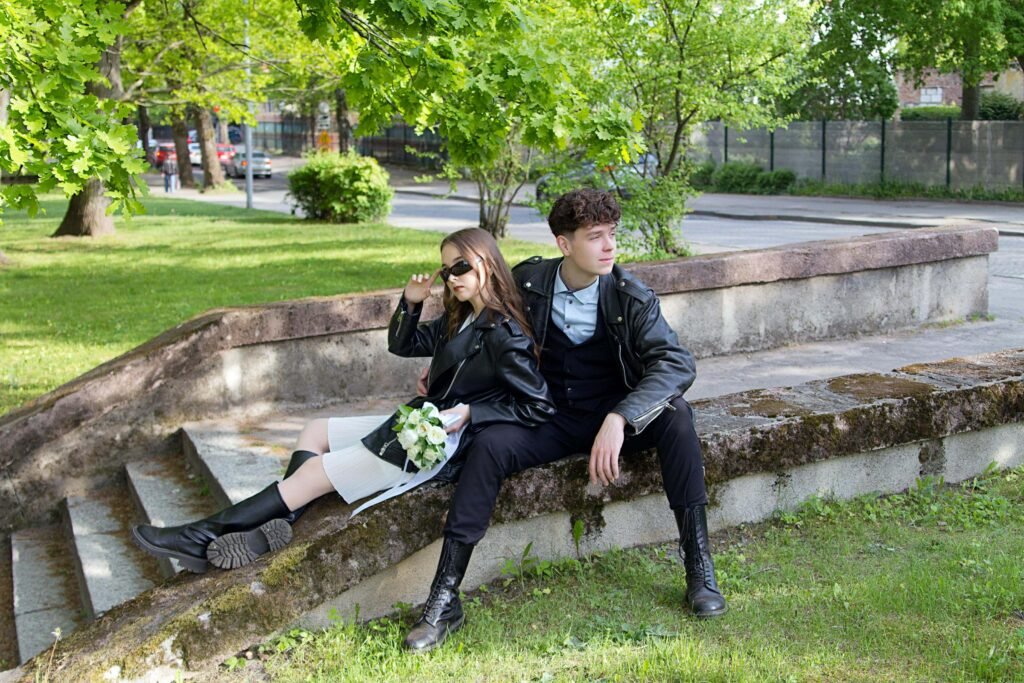 How often do couples fight - Young couple sitting separately on park steps looking in different directions after argument, illustrating emotional distance and conflict that many relationships experience