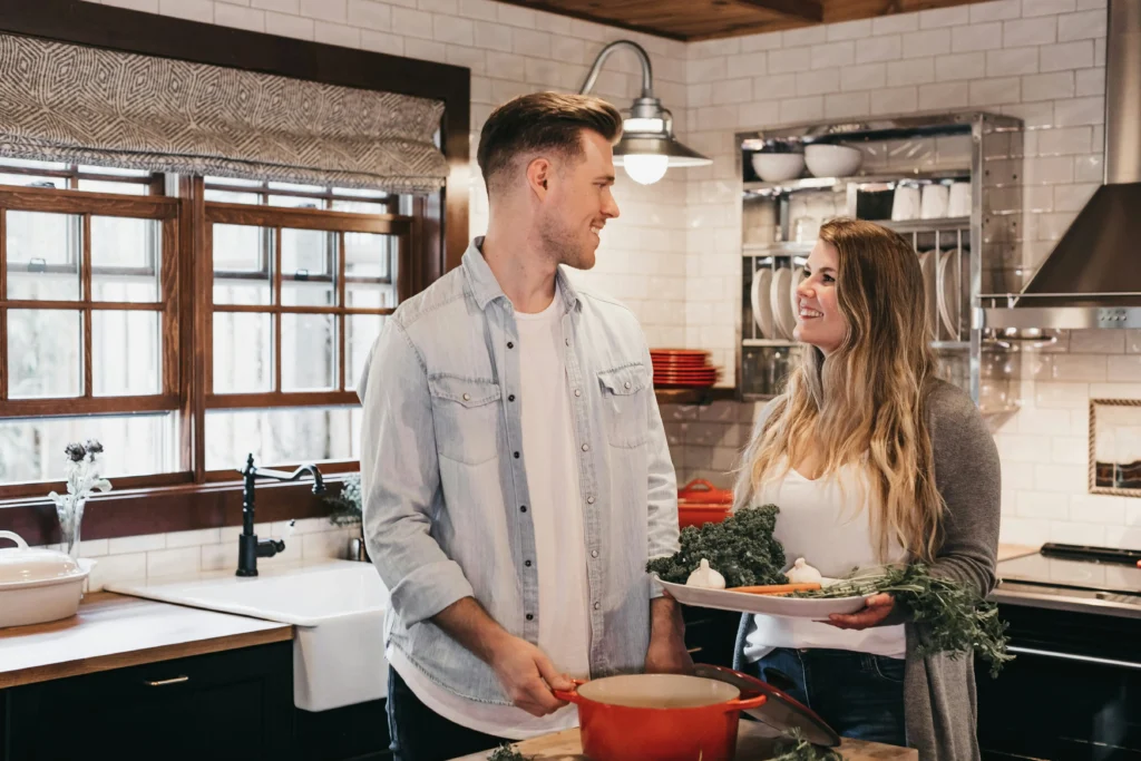 Smiling wife and husband cooking with fresh vegetables illustrating how to be a better wife through equal partnership in daily tasks