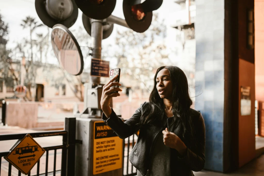 A woman using her phone for a video call, symbolizing digital connection and how to be intimate in a long-distance relationship.